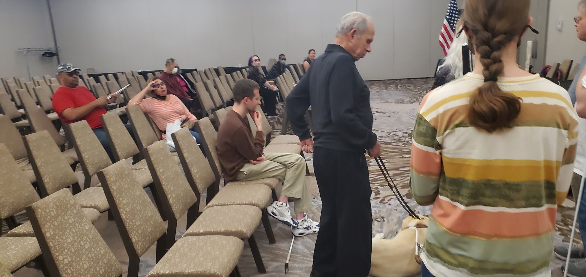 A group of people are sitting in rows of chairs in a room.