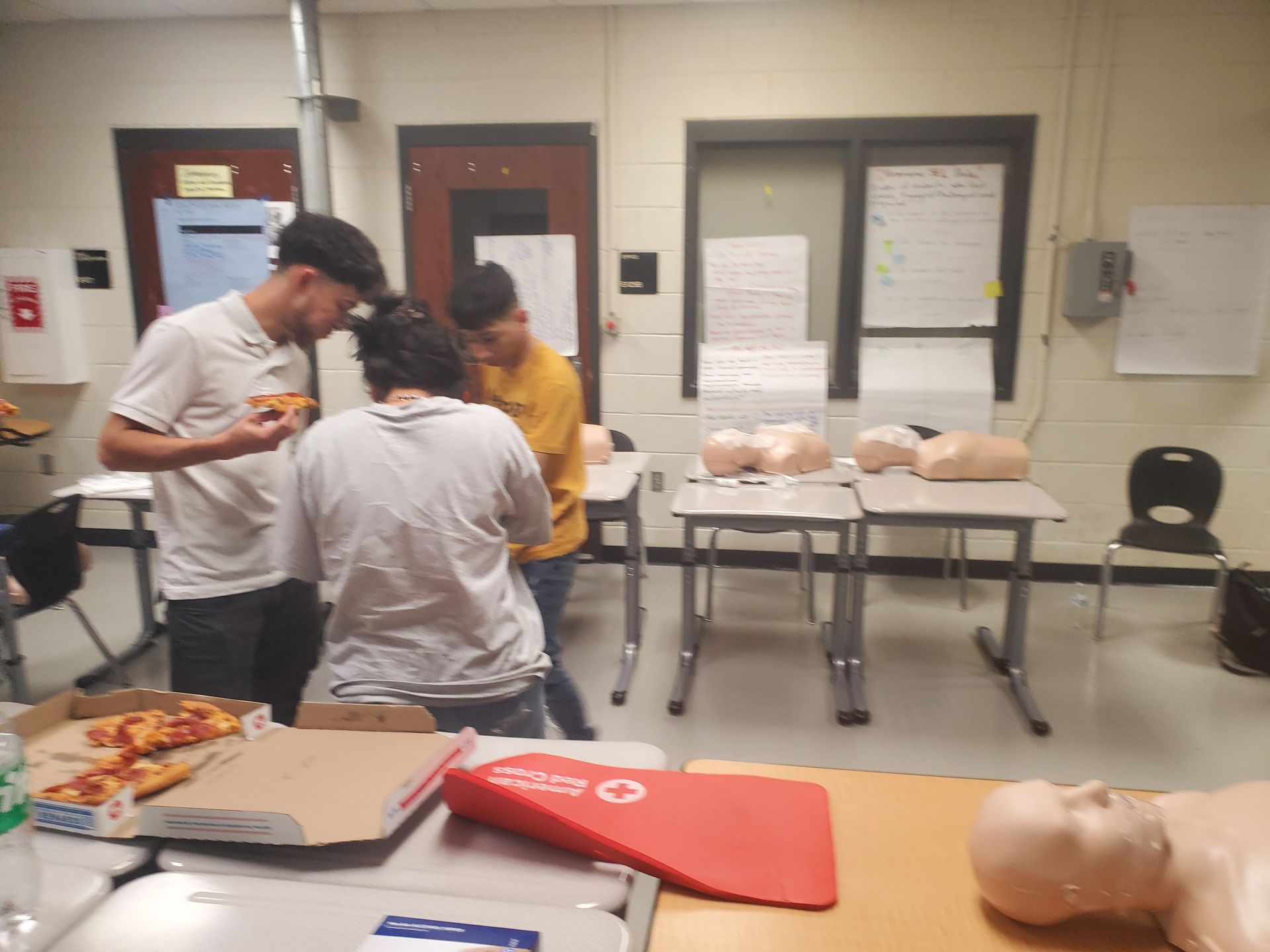 A group of people are standing around a table with a red folder that says o on it