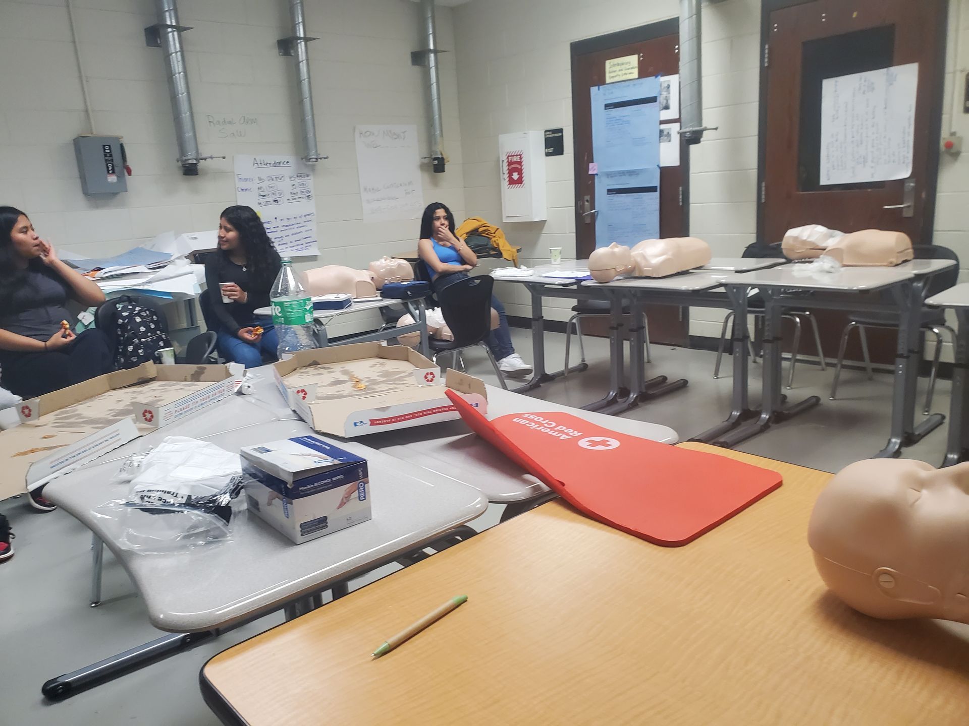 A group of people are sitting at tables in a classroom.