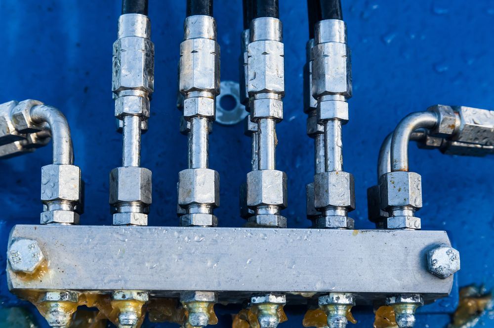 Close-up of Hydraulic Lines and Fittings on Blue Background — Alloway Hydraulics in Mount Saint John, QLD