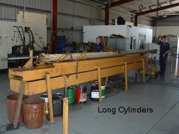 Workshop With Yellow Workbench Holding Long Cylinders — Alloway Hydraulics in Mount Saint John, QLD