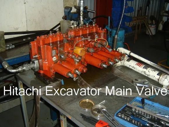 Hitachi Excavator Main Valve, Orange and Silver, on a Workbench — Alloway Hydraulics in Mount Saint John, QLD