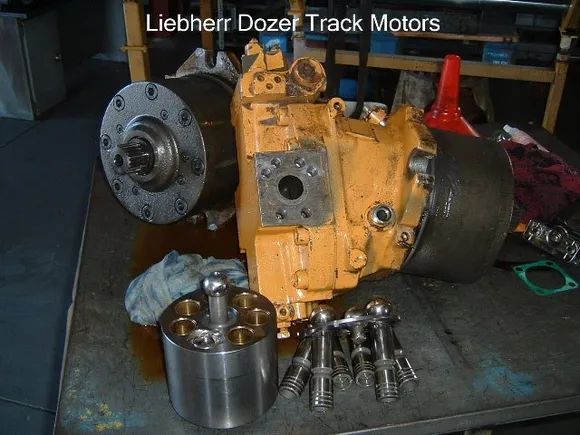 Yellow Liebherr Dozer Track Motor Parts on a Workbench — Alloway Hydraulics in Mount Saint John, QLD