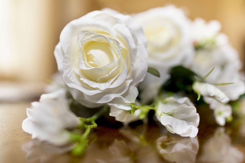 Un primo piano di un bouquet di rose bianche su un tavolo.