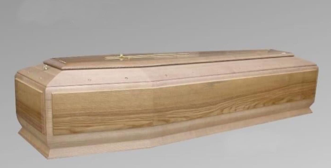 Una bara di legno è appoggiata su una superficie grigia.