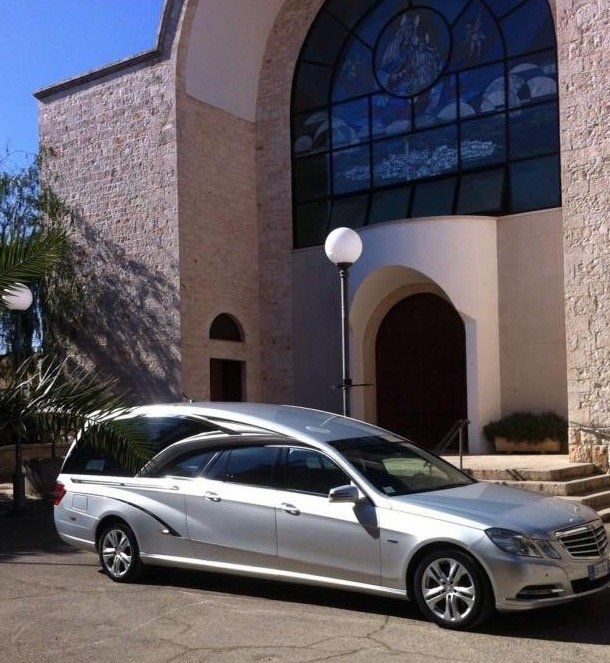 Un'auto argentata è parcheggiata davanti a una chiesa