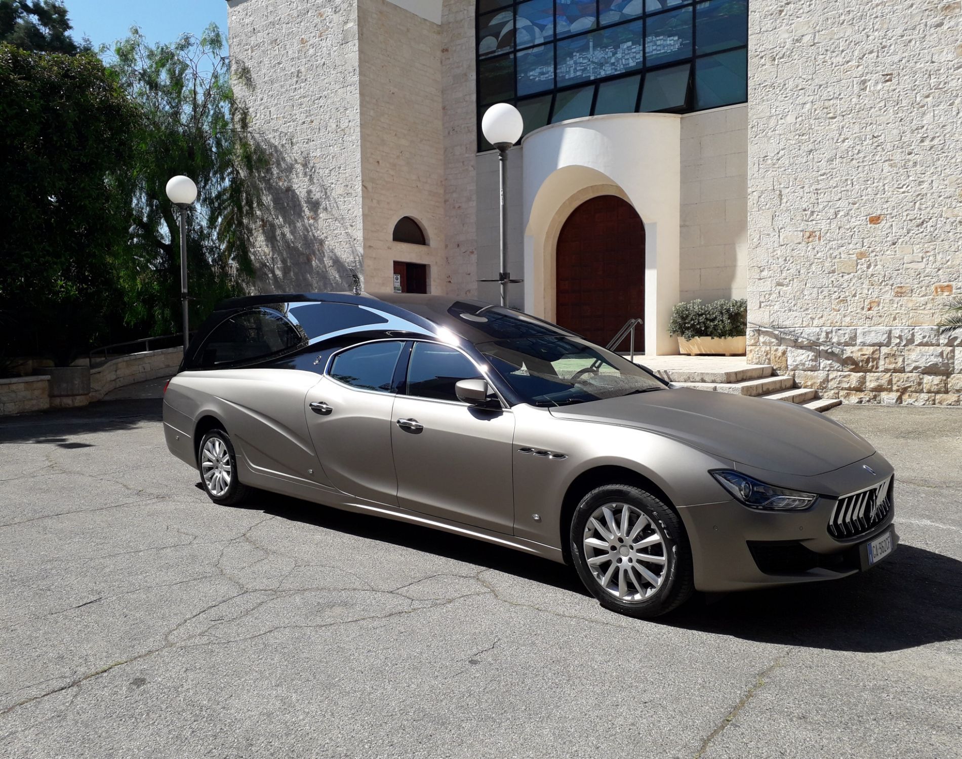 Un'auto argentata è parcheggiata davanti a un edificio.