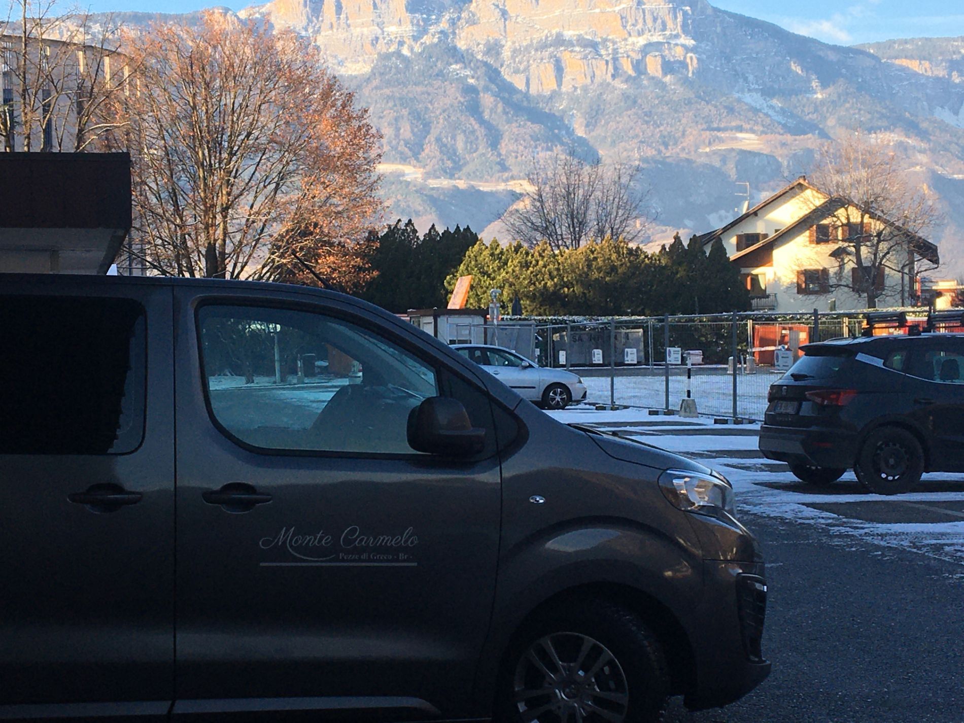 Un furgone è parcheggiato in un parcheggio con le montagne sullo sfondo.