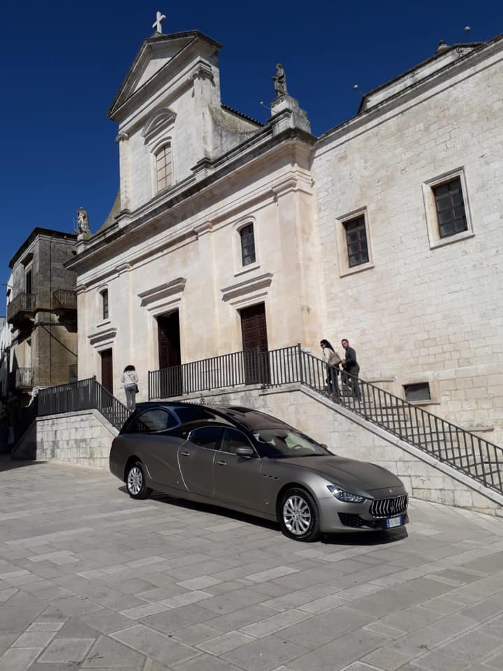 Un'auto è parcheggiata davanti a un grande edificio
