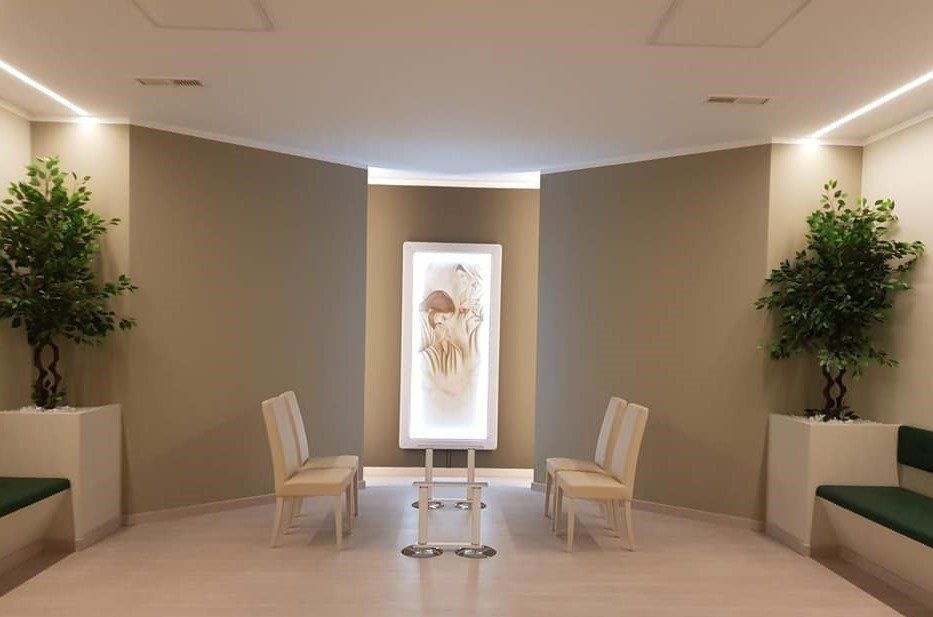 Una sala d'attesa con sedie, un tavolo e un quadro alla parete.