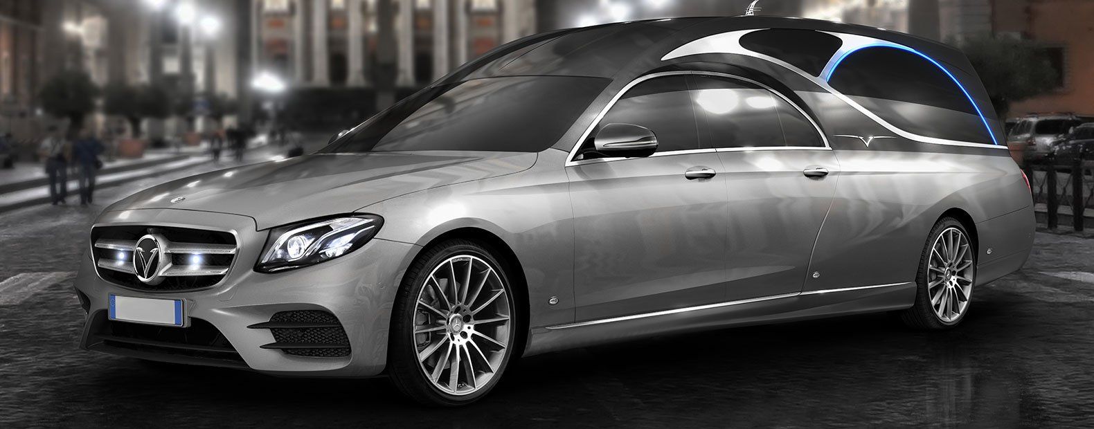 Un'auto argentata è parcheggiata sul ciglio di una strada cittadina di notte.