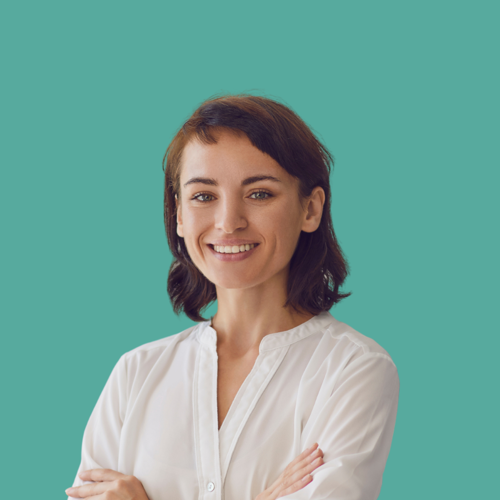 A woman in a white shirt is smiling with her arms crossed.