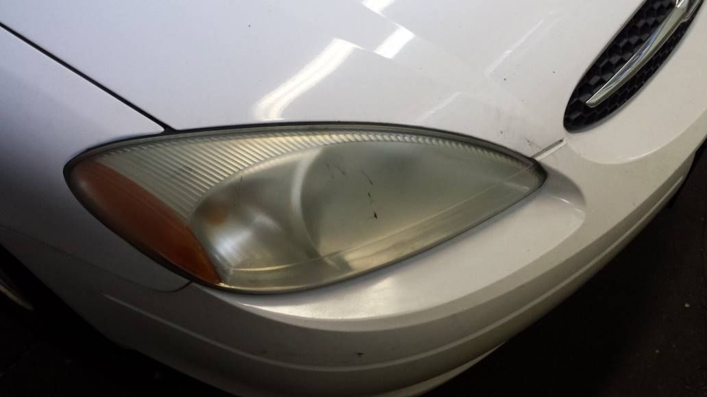 A close up of a white car 's headlight