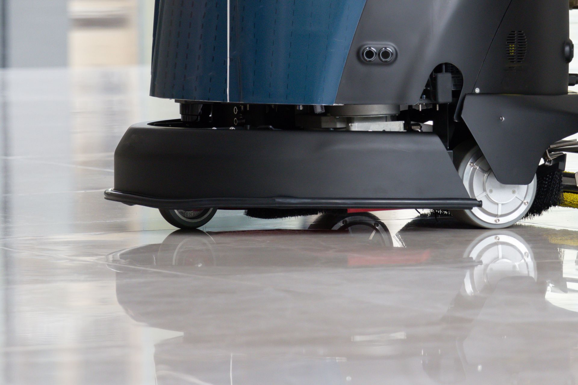 Macchina lavapavimenti che strofina un pavimento lucido e di colore chiaro.