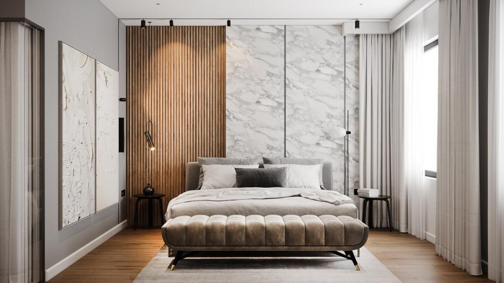Bedroom with marble and wood accent wall, bed, bench, side tables, window, and art.