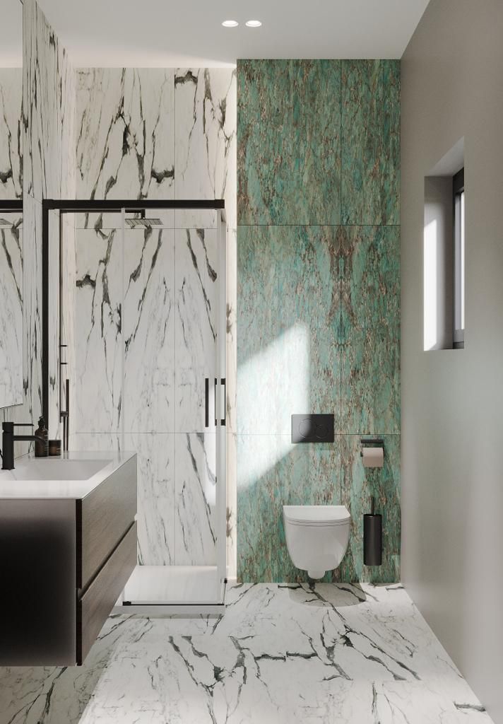 Bathroom with marble and green textured walls, black fixtures, and a glass shower.
