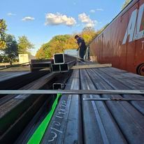 A man is standing on top of a pile of metal.