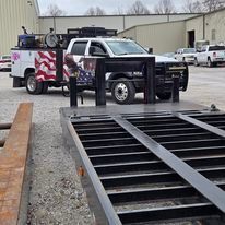 A truck is parked next to a trailer in a parking lot.