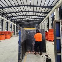 A man is welding a piece of metal in a factory.