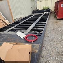 There is a box on the ground next to a dumpster.