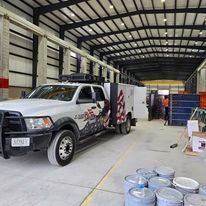 A white truck is parked in a large warehouse.
