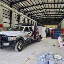 A white truck is parked in a large warehouse.