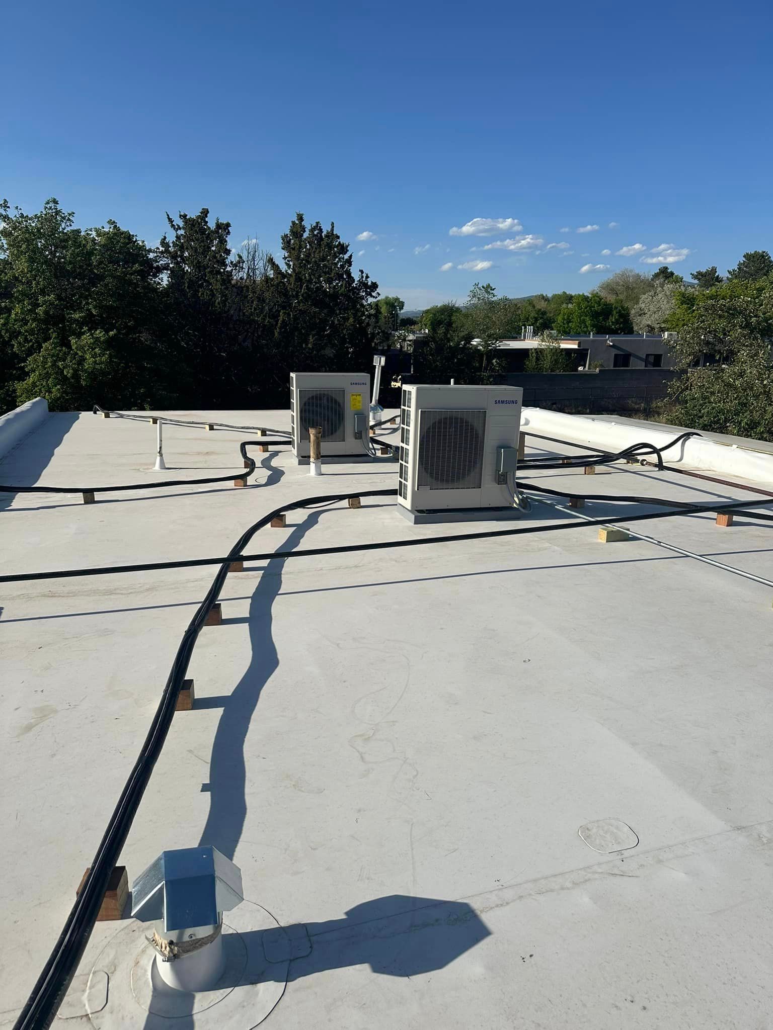 Two air conditioners are on the roof of a building