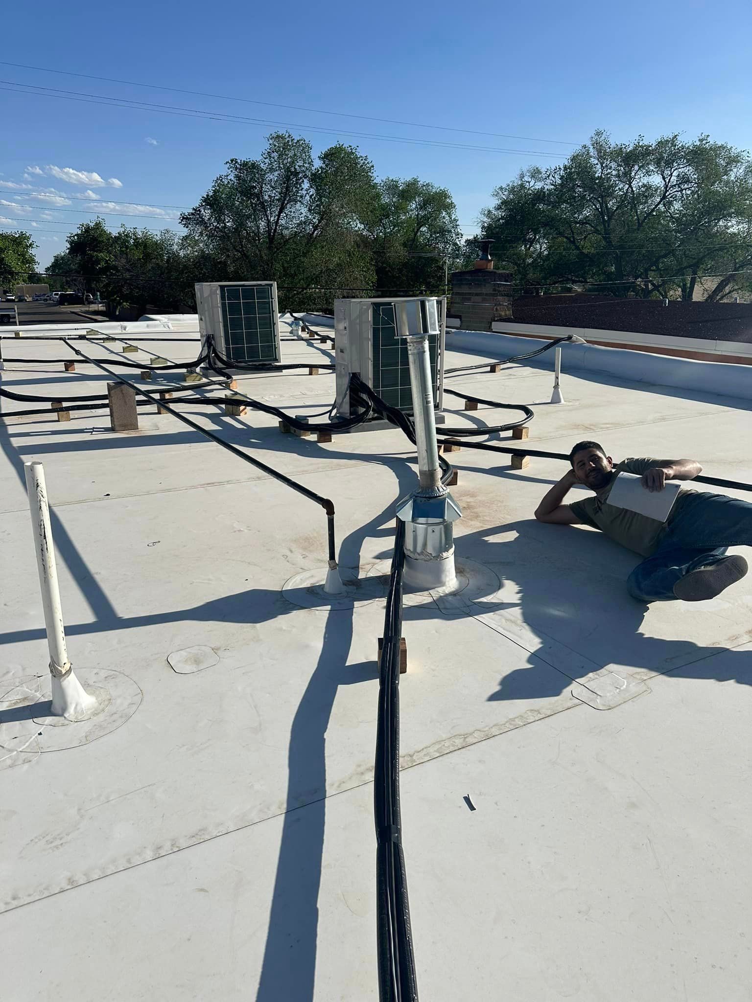 A man is laying on the roof of a building.