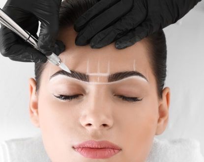 A woman is getting her eyebrows fixed.