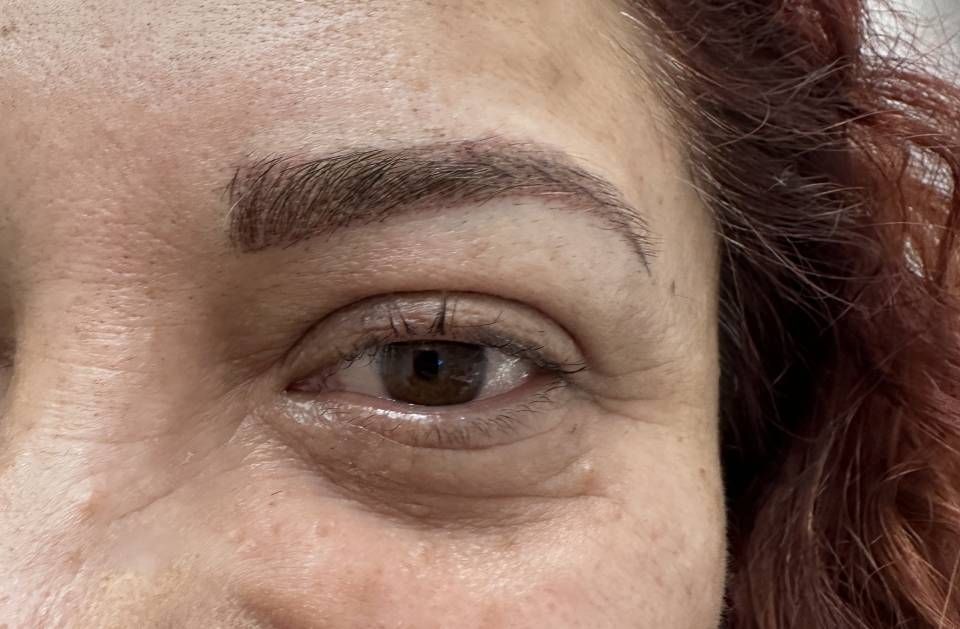 A close up of a woman 's eye with red hair.