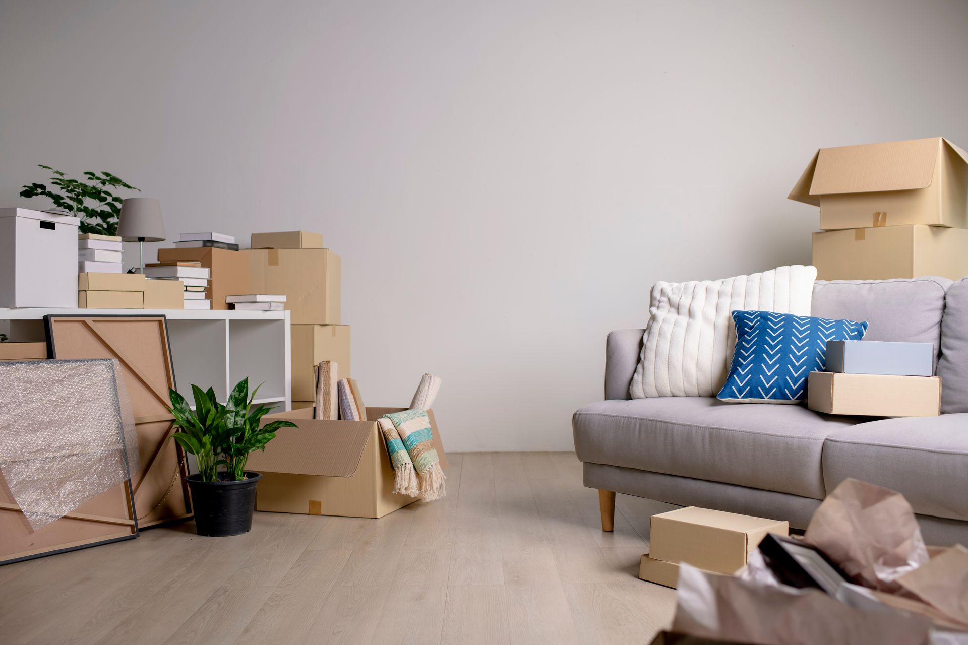 Un soggiorno pieno di scatoloni e un divano.