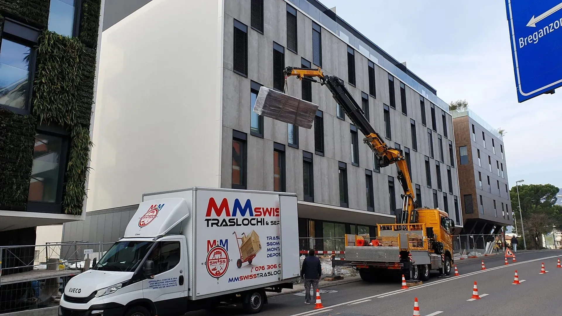 Un camion mms bianco è parcheggiato davanti a un grande edificio.