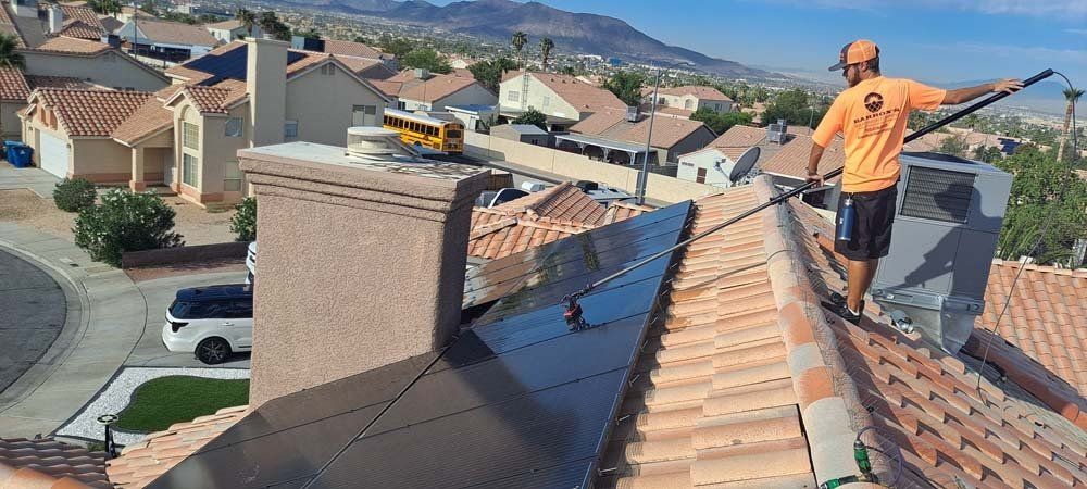 Worker cleaning solar panels in a roof