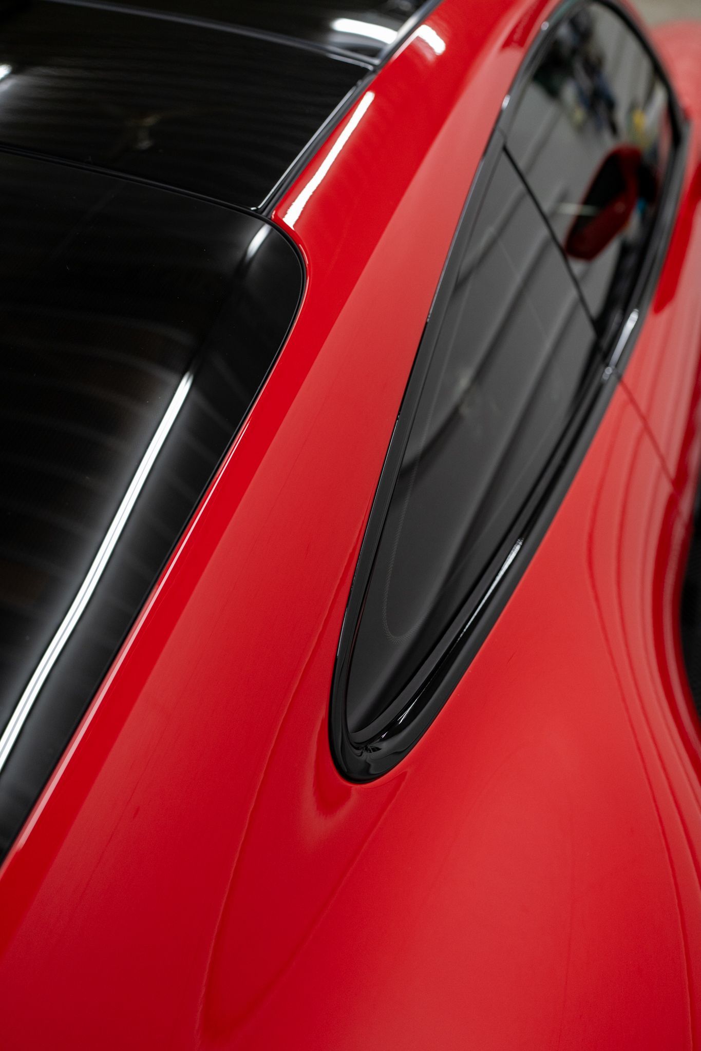 Red sports car, angled view of the rear window and roof. Shiny exterior.