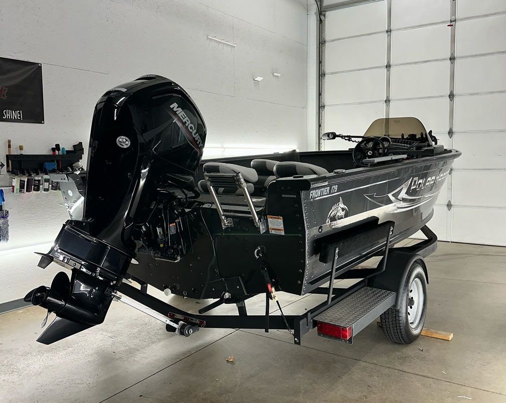 A boat is sitting on a trailer in a garage.