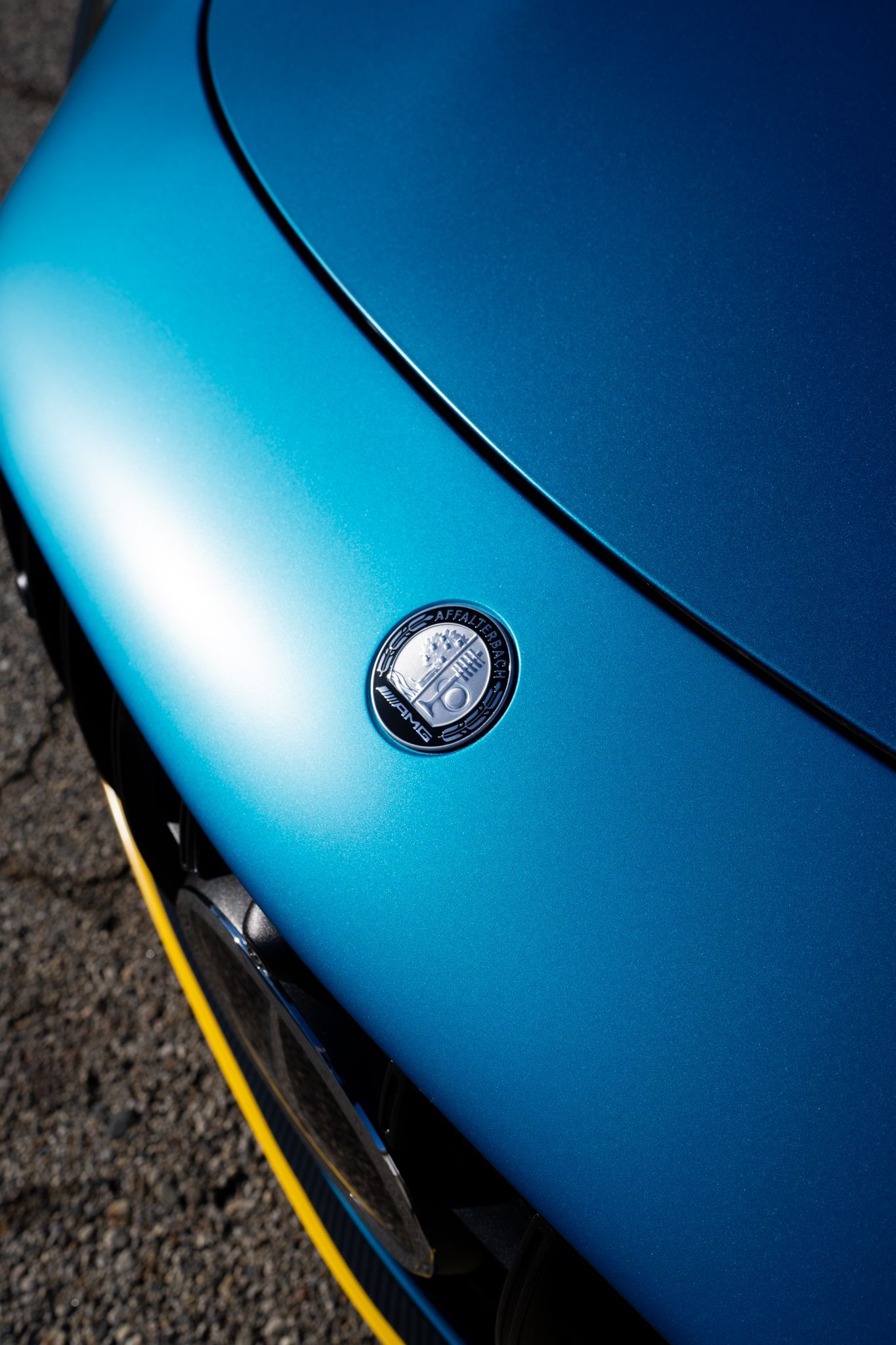 Blue car hood with a circular emblem.