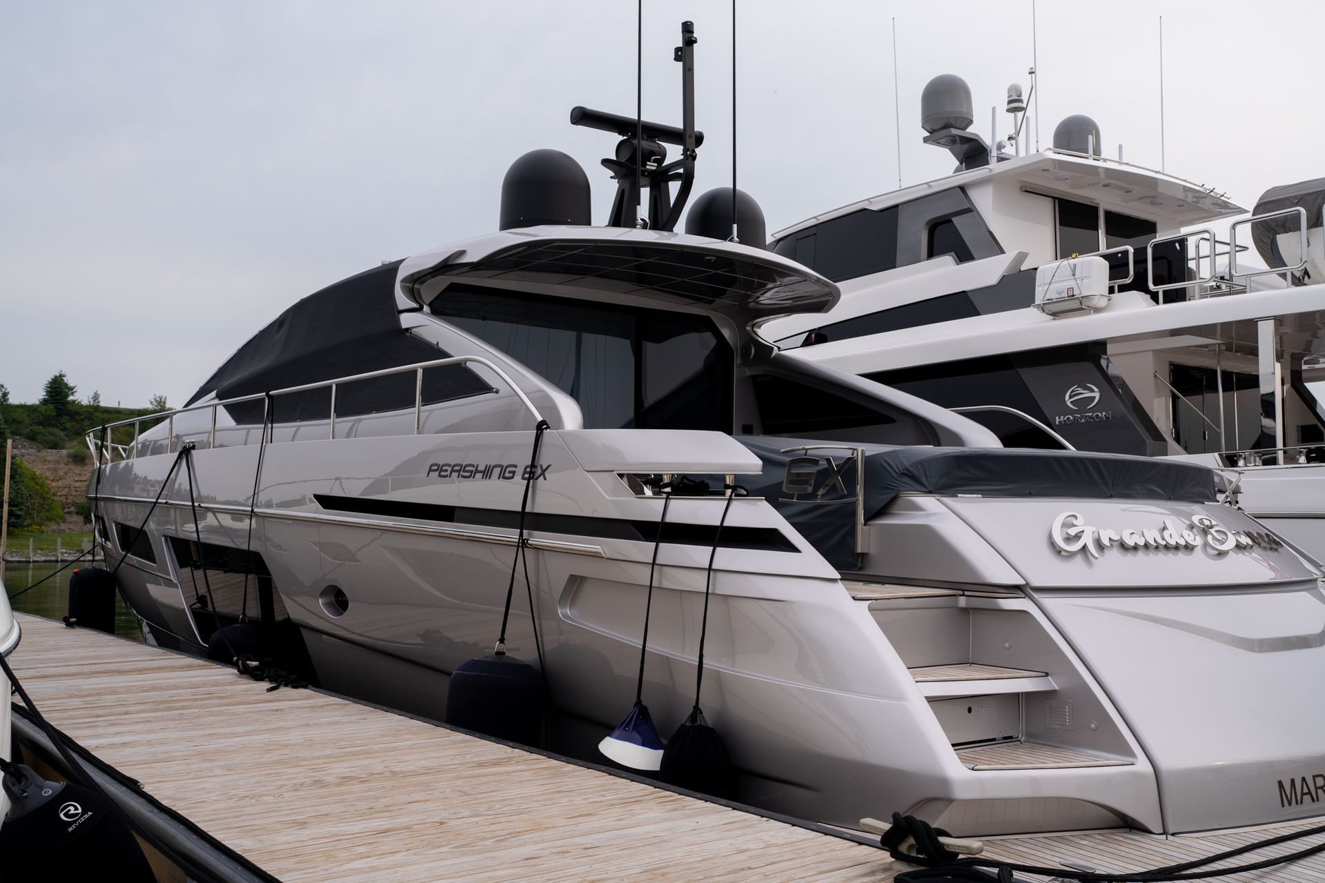 Two sleek white luxury yachts docked side by side at a marina.