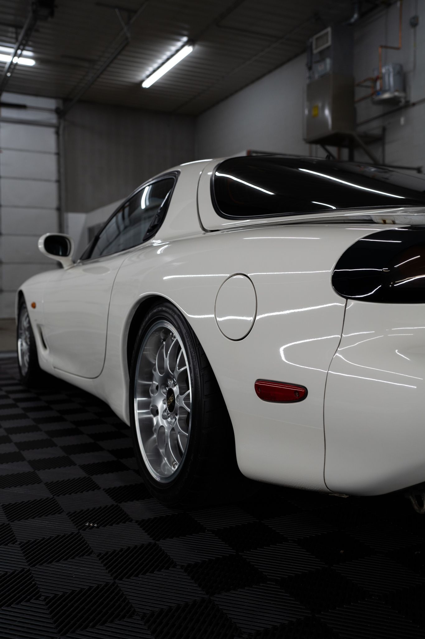 A white sports car is parked in a garage.