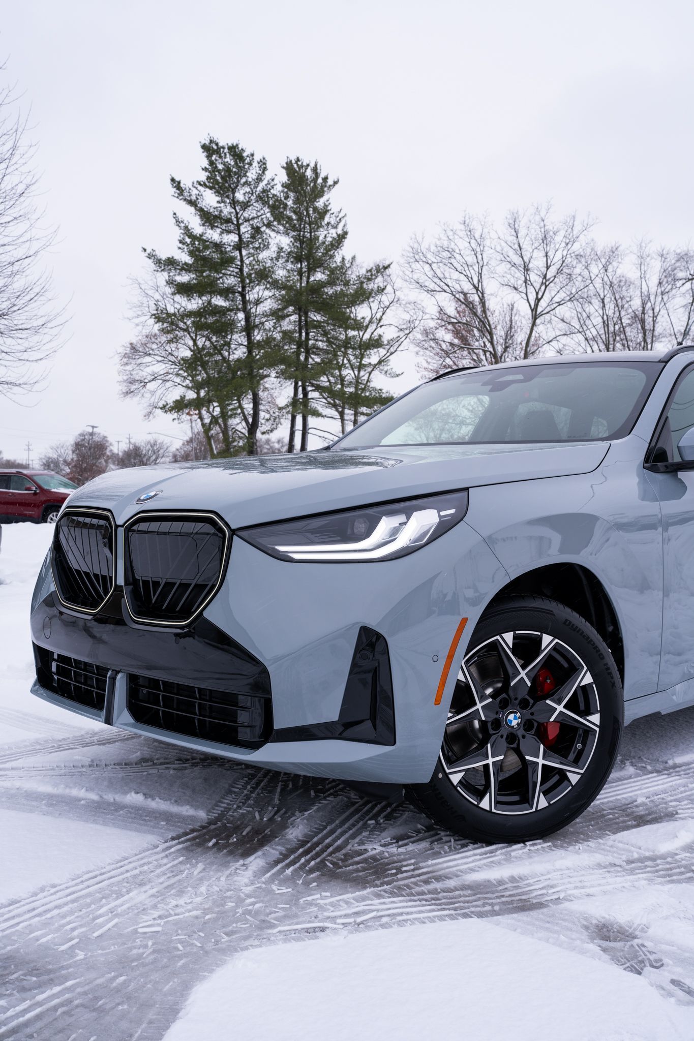 A light blue BMW SUV parked on a snow-covered road.