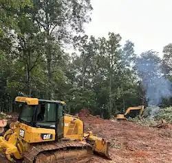 A yellow excavator is digging a hole in the ground.