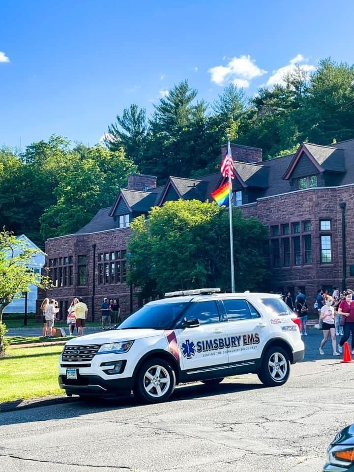 A simsbury EMS flycar is parked in front of a brick building