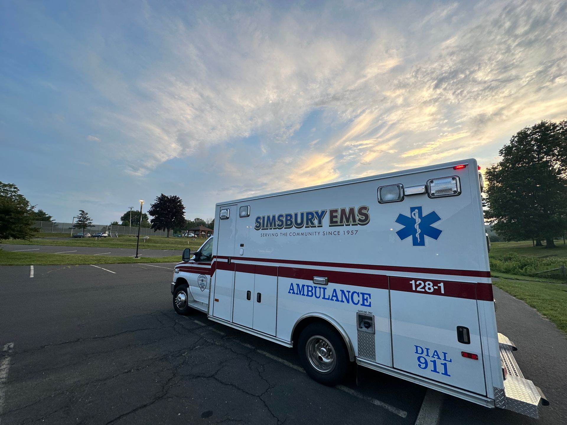 A white and red Simsbury ambulance is parked in a parking lot.