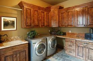 A laundry room with a sink , washer and dryer , and wooden cabinets
