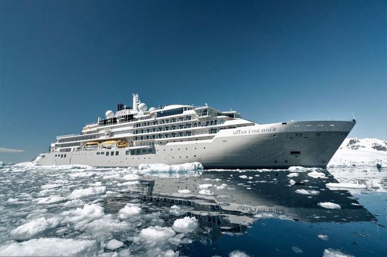 A large cruise ship is floating on ice in the ocean