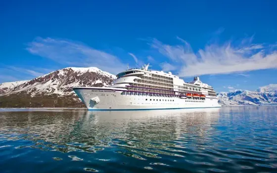 A large cruise ship is floating on top of a body of water.
