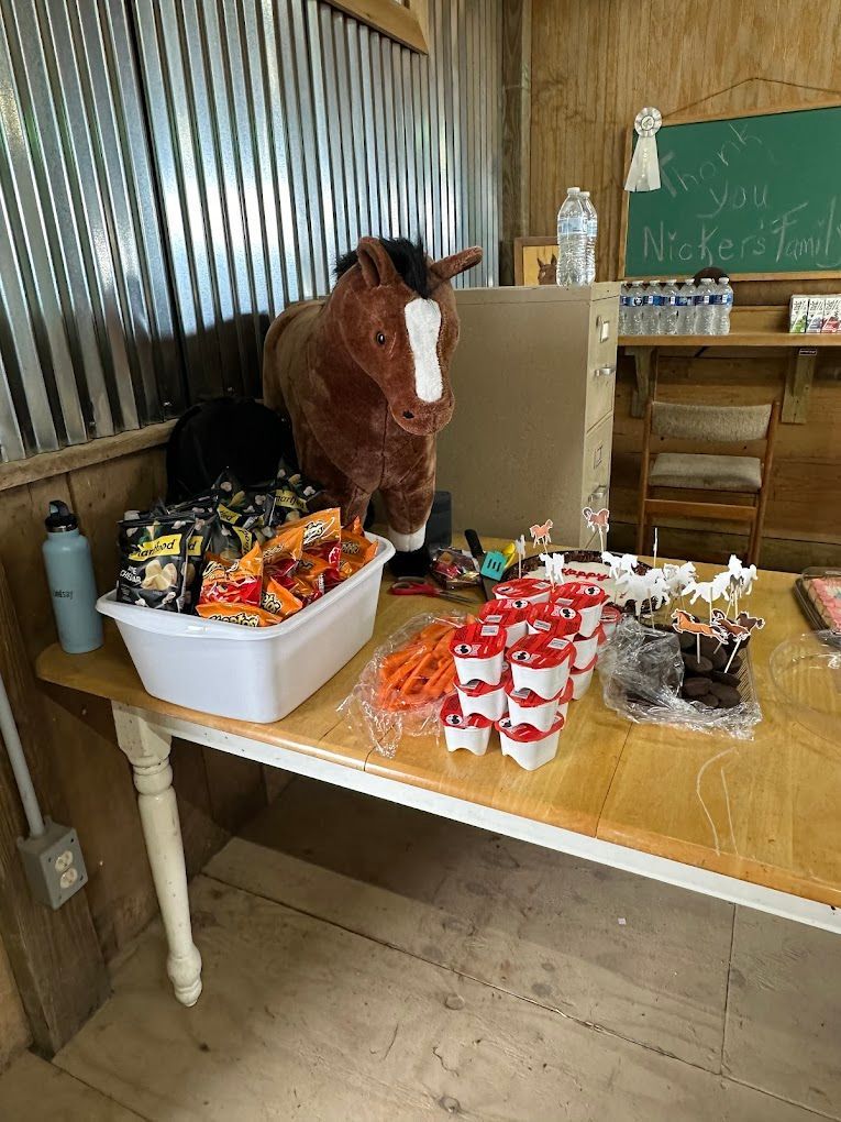 A stuffed horse is sitting on top of a table with snacks.
