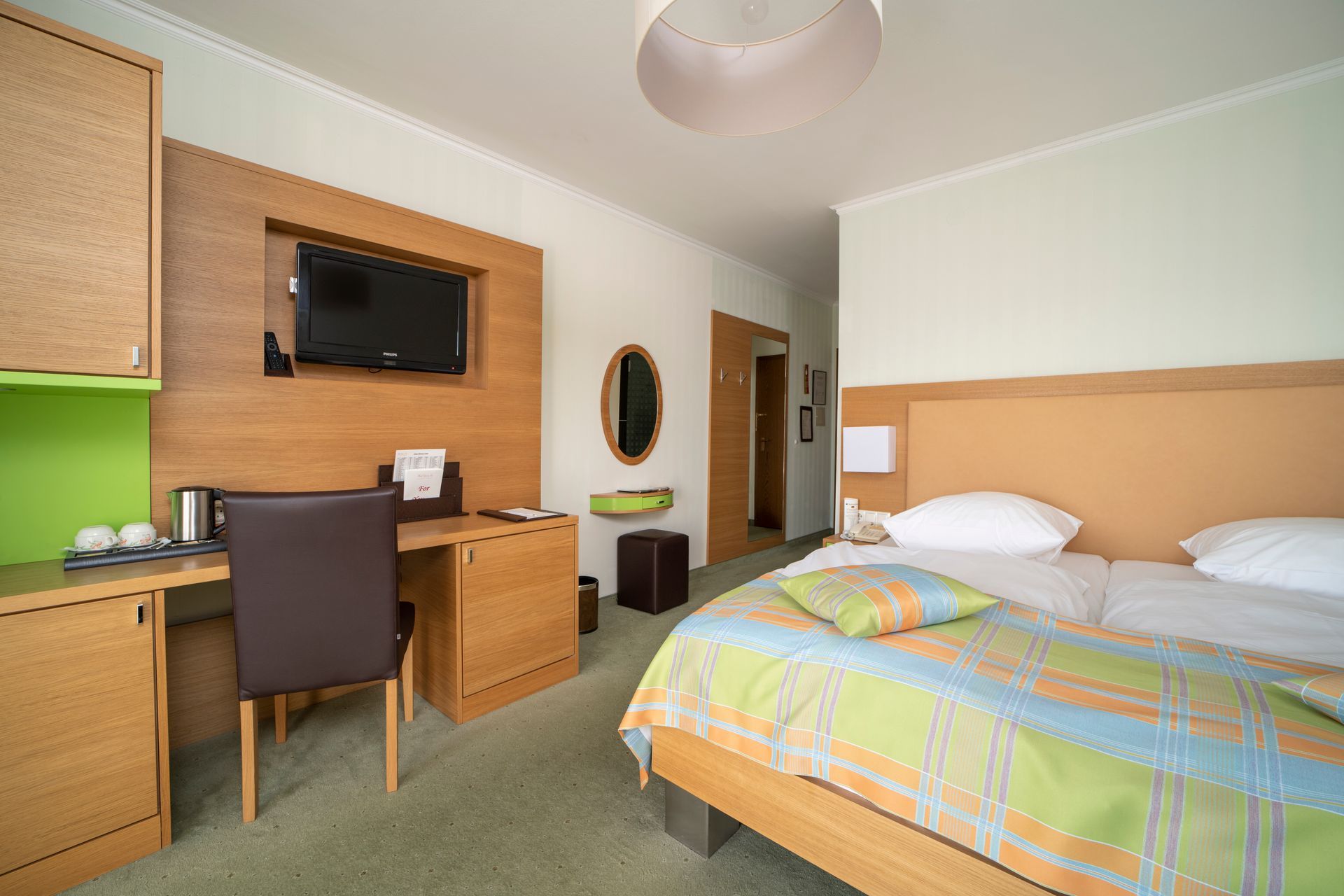 Chambre d'hôtel avec un lit, des chaises, une table et une fenêtre avec des rideaux.