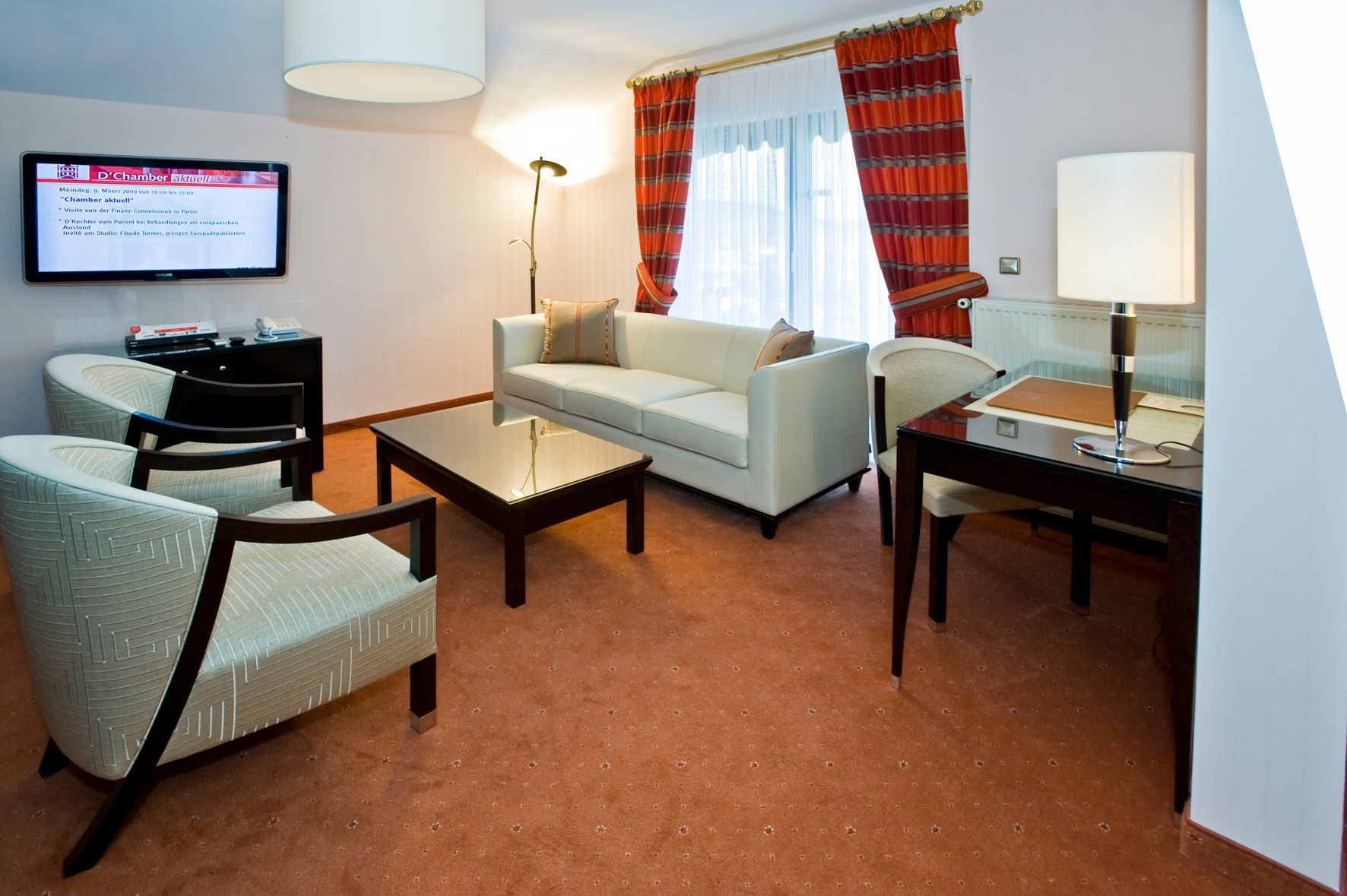Chambre avec armoire en bois, lit avec tête de lit beige et accès au balcon.