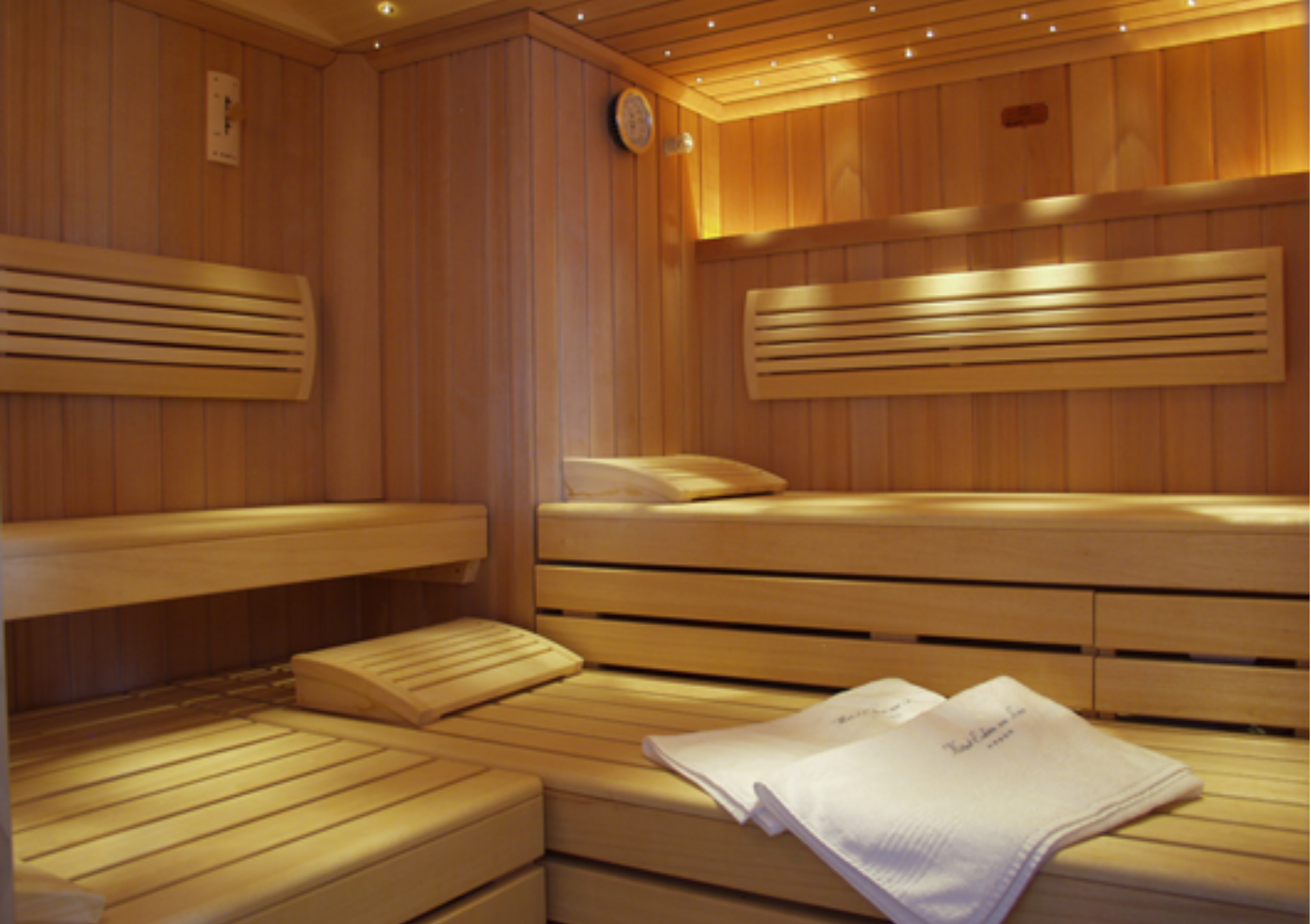 Chambre d'hôtel avec deux lits jumeaux, une télévision et une porte ouverte sur un salon.