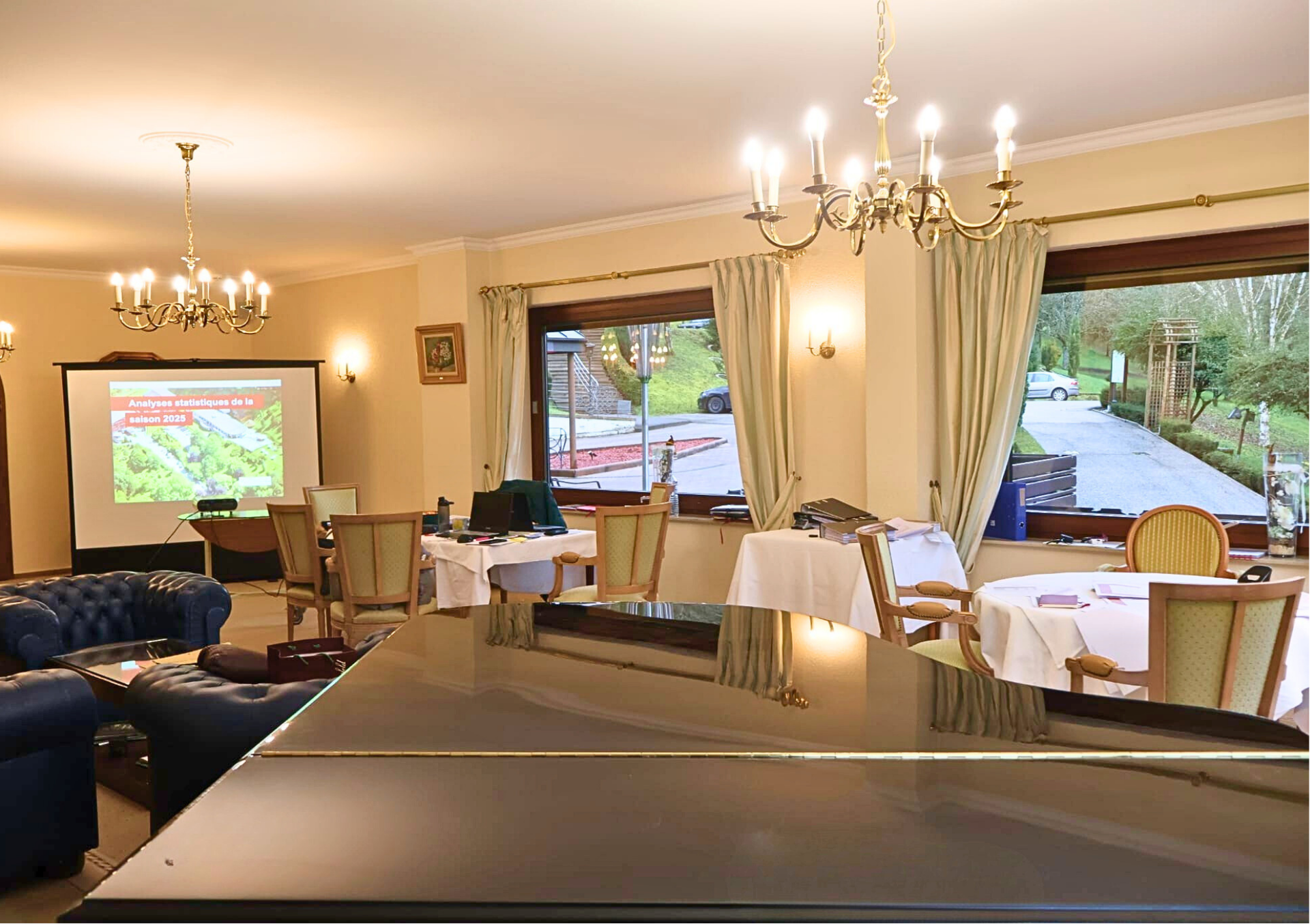 Une longue table de réunion rectangulaire dressée pour un rassemblement, entourée de chaises dans une pièce formelle.